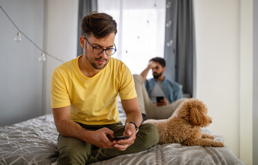 Wall Mural - Sad homosexual gay couple arguing in bedroom at home.