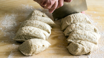 Rye flour bread baking dough and dough cutting knife in hands, close-up, home baking, authentic hobby