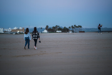 Dos amigas pasando el tiempo en la playa tomando fotos  y hablando