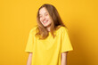 Close-up portrait of a cheerful girl. Happy smiling teenage girl on a yellow background.