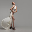 © Alena - Fashion woman posing in white dress in full growth. Gray background