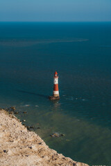 Wall Mural - Red and white–striped Beachy Head Lighthouse against chalk cliffs,  view from top of Seven Sisters, Clifftop Paths Nature Reserve. South of England