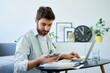 © baranq - Man working at home checking his mobile phone