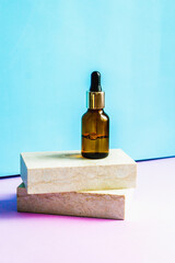 a cosmetic jar with an eyedropper stands on two granite slabs like on catwalks. the concept of minim