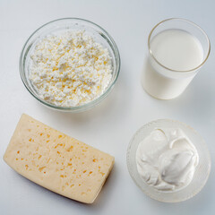 Top view still life with dairy products cottage cheese, sour cream and yogurt on a white background