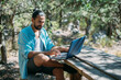 © Anna - Male tourist working on a laptop outdoors in a camping.