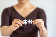 © Montri Thipsorn - Closeup of woman hand holding and connecting two white paper jigsaw puzzle. Using as Business solutions and strategy concept.