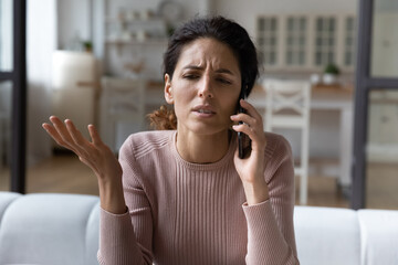 Talking about problems. Sad young hispanic female hold phone to ear discuss bad news with friend share emotional stress. Concerned female patient call doctor speak on health complaints ask for advice