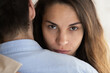 © fizkes - Close up portrait of young Latino woman hug husband feel unsure doubtful about relationships. Millennial female embrace man lover look at camera thinking. Cheating, relation problem concept.