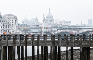 Wall Mural - City of London and St. Pauls cathedral in raining, misty day view from the River Thames. Empty streets of London during national lockdown UK, 2021