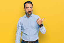 Middle Aged Man With Beard Wearing Business Shirt Surprised Pointing With Hand Finger To The Side, Open Mouth Amazed Expression.
