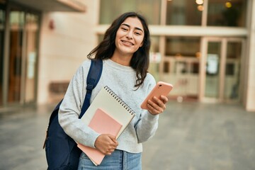 Young middle east student girl smiling happy using smartphone at the city.