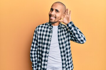 Canvas Print - Hispanic adult man wearing casual clothes smiling with hand over ear listening and hearing to rumor or gossip. deafness concept.