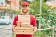 © Krakenimages.com - Young caucasian deliveryman smiling happy holding delivery food at the city.