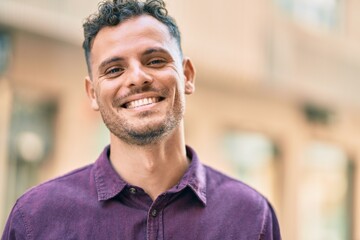 Poster - Young hispanic man smiling happy standing at the city.