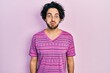 Handsome hispanic man wearing casual pink t shirt puffing cheeks with funny face. mouth inflated with air, crazy expression.