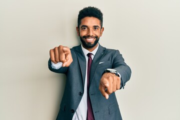 Sticker - Handsome hispanic man with beard wearing business suit and tie pointing to you and the camera with fingers, smiling positive and cheerful