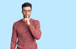 © Krakenimages.com - Young handsome hispanic man wearing winter sweater and glasses asking to be quiet with finger on lips. silence and secret concept.