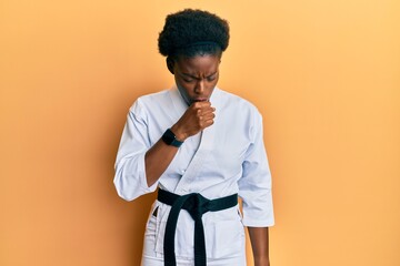 Canvas Print - Young african american girl wearing karate kimono and black belt feeling unwell and coughing as symptom for cold or bronchitis. health care concept.