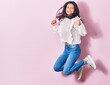 © Krakenimages.com - Young beautiful latin woman wearing casual clothes smiling happy. Jumping with smile on face doing ok sign with thumbs up over isolated pink background