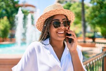 Young African American Woman With Braids Smiling Happy Spaking On The Phone Outdoors On A Sunny Day Of Summer