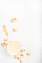 Wall Mural - Vegan Cashew nut milk on white background. Non dairy alternative vegan drink. Healthy vegetarian food and beverage. Copy space, top view