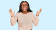 Young black woman wearing casual clothes and glasses celebrating mad and crazy for success with arms raised and closed eyes screaming excited. winner concept