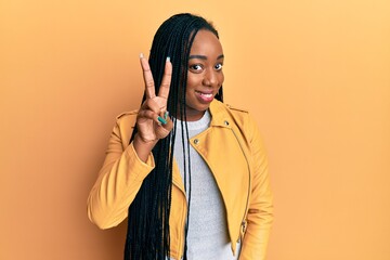 Young african american woman wearing casual jacket showing and pointing up with fingers number two while smiling confident and happy.