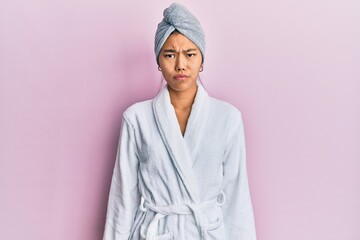 Poster - Young chinese woman wearing shower towel cap and bathrobe depressed and worry for distress, crying angry and afraid. sad expression.