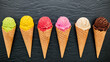 Various of ice cream flavor in cones blueberry ,lime ,pistachio ,almond ,orange ,chocolate ,vanilla and coffee set up on dark stone background . Summer and Sweet menu concept.