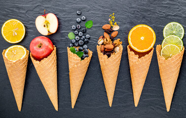 Fototapete - Various of ingredient for ice cream flavor in cones  set up on dark stone background .