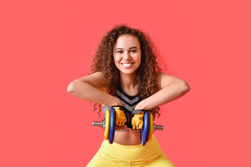 Poster - Beautiful young woman training with dumbbell on color background