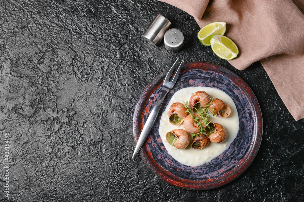 Plate with tasty snails on dark background