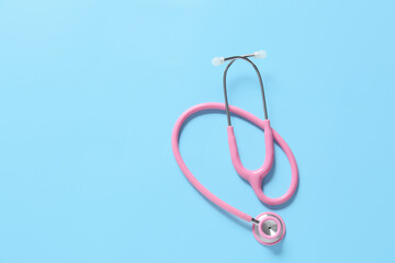 Modern stethoscope on color background