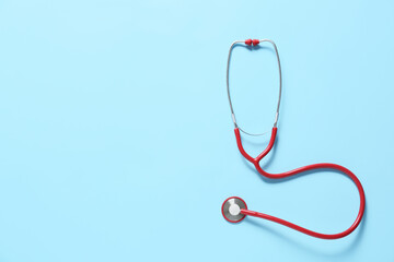 Modern stethoscope on color background