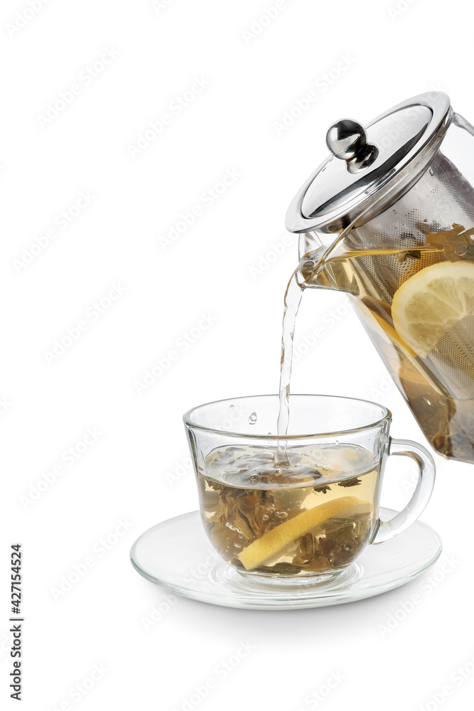 Pouring of green tea from teapot into cup on white background