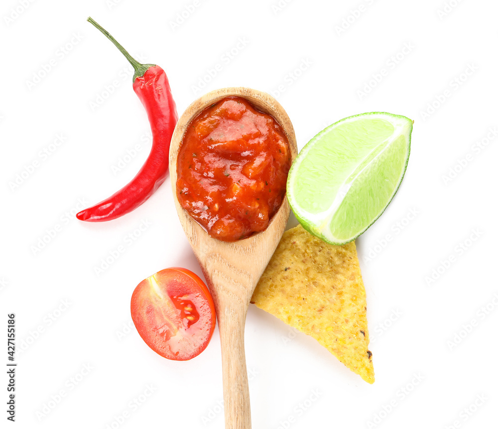 Spoon with tasty salsa sauce and nachos on white background