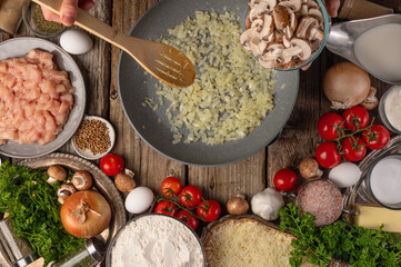 Wall Mural - Chef prepares for frying in a pan, on a background with ingredients. Culinary recipes