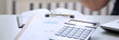© H_Ko - Black calculator and financial statistics on clipboard pad