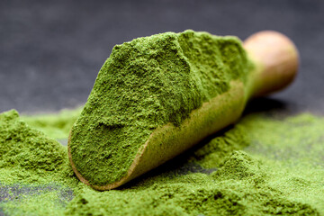 Wall Mural - Green tea, matcha. Powdered young barley or wheat grass on wooden scoop. Detox superfood concept.