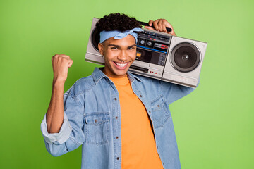 Poster - Photo portrait of handsome guy keeping boom box gesturing like winner smiling isolated bright green color background