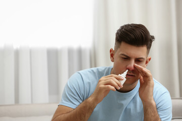 Ill man using nasal spray at home