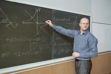 Aufkleber - Confident mature professor standing in front of blackboard in lecture hall, pointing at graph and explaining it while looking at audience