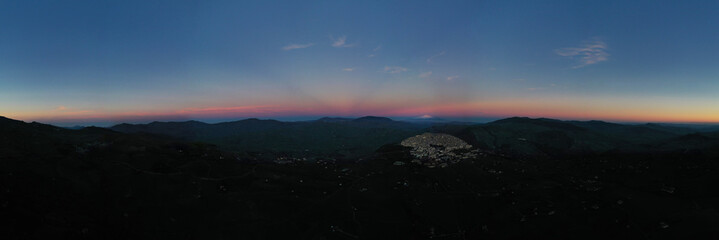 180 degree photo of the typical village of Gangi with a view of the Etna volcano during sunset. Typical Sicilian village. Nature on the Madonie in winter. Wheat fields.