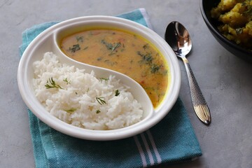 Healthy nutritious Indian comfort food Dal Chawal thali or Dal Rice, also commonly known as Varan bhat in Marathi. Served in two way ceramic plate. Over white background with copy space.