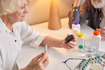 Wall Mural - Close-up Of A Woman's Hand Testing High Blood Sugar With Glucometer