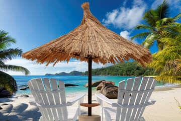 Parasol and beach chairs on Sunny beach with palms and turquoise sea in Paradise island.	