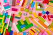 Plastic constructor details on pink background close up