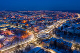 Fototapeta Miasto - Beautiful evening top view of the city. Evening, night illumination in the city. Winter city in the snow.