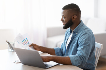 Wall Mural - Remote Business. Black Entrepreneur Working With Papers And Laptop At Home Office